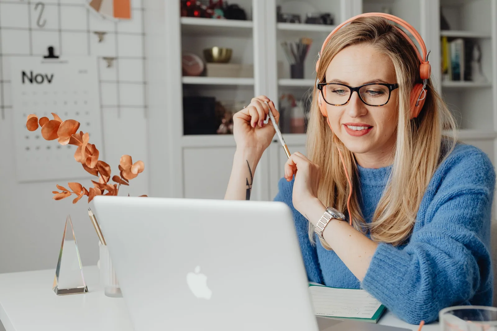 Una mujer estudia con un portátil y auriculares