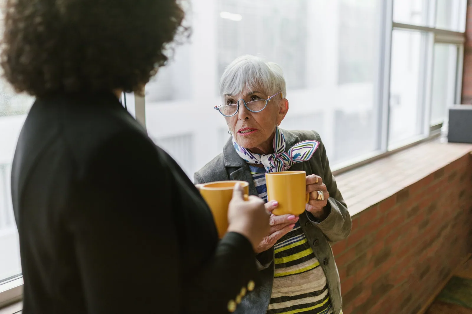 Dos compañeras comparten una pausa con café
